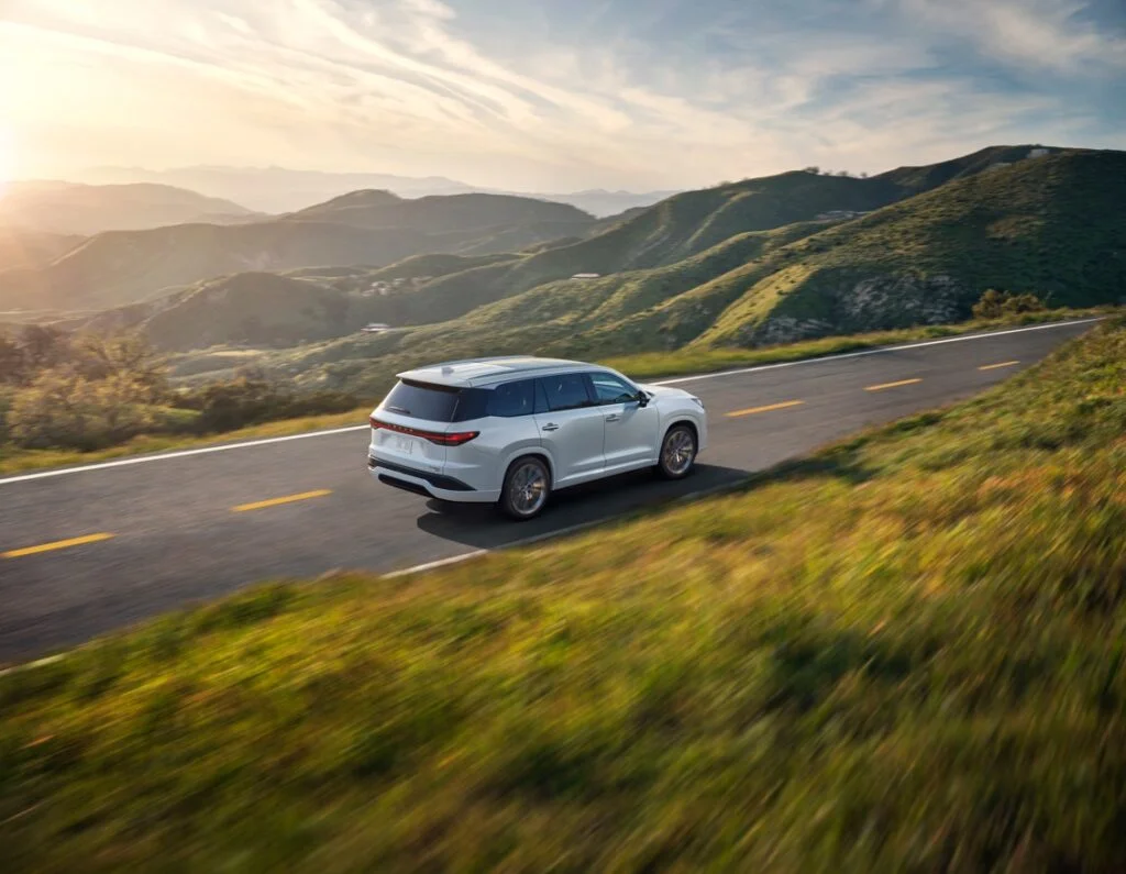 White Lexus TX 350 driving on a road in the mountains.